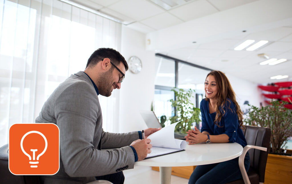 Two people discussing work in an office setting